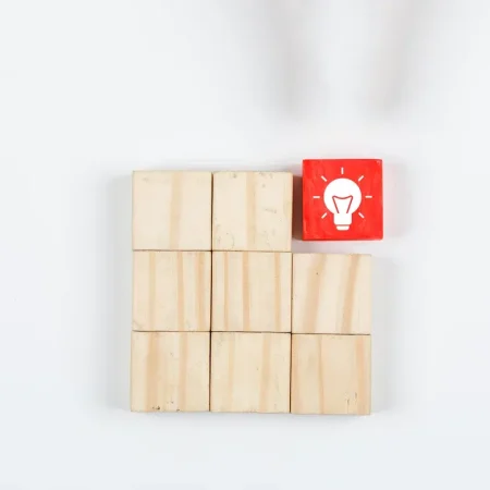 conceptual-idea-hand-pointing-idea-with-wooden-blocks-white-background-top-view-horizontal-image